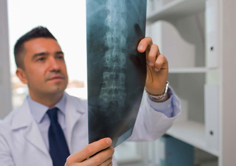 Doctor at Advanced Physical Medicine & Rehab examining patient x-rays for spine injury